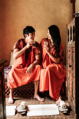 a man and woman sitting on the floor drinking wine at Villa Maroc Resort in Pran Buri