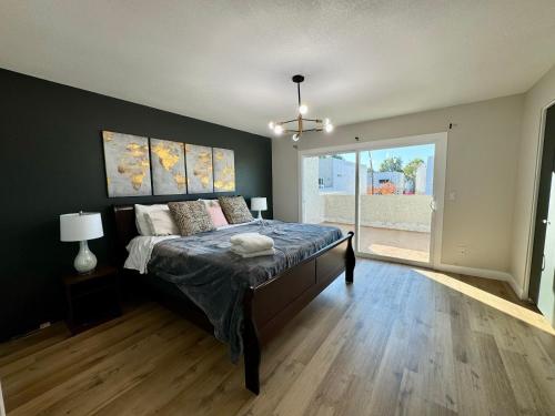 a bedroom with a bed and a large window at beautifully renovated townhouse in Tempe