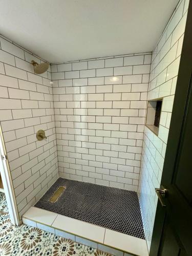 a bathroom with a shower with white tiled walls at beautifully renovated townhouse in Tempe