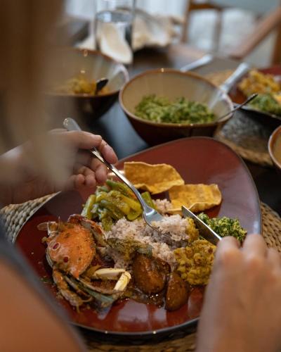 a table with a plate of food on a table at Beacon By The Bay Villas and Suites by the Clarks in Matara