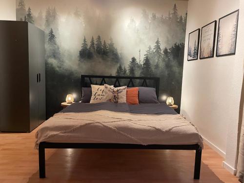 a bedroom with a bed with a forest mural on the wall at CASA BLACK FOREST - Freudenstadt Kniebis in Freudenstadt