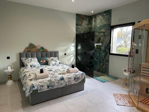 une chambre avec un lit et une douche en verre dans l'établissement Villa BHD-Lodge & Spa, la tentation du luxe, à Blandouet