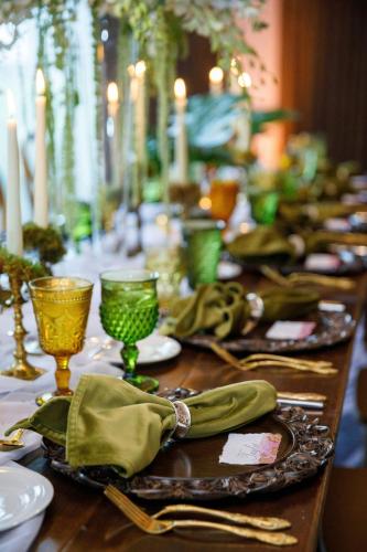 a long table with green plates and glasses on it at Castle Hotel, Autograph Collection in Orlando