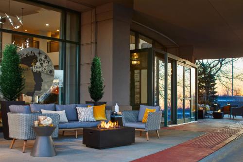 a lobby with a couch and chairs and a fire pit at Renaissance Chicago Glenview Suites Hotel in Glenview