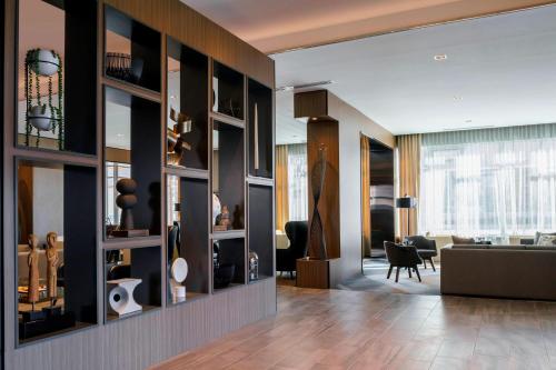 a living room with a large wall of shelves at AC Hotel by Marriott Chapel Hill Downtown in Chapel Hill