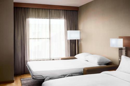 a hotel room with two beds and a window at AC Hotel by Marriott Chapel Hill Downtown in Chapel Hill