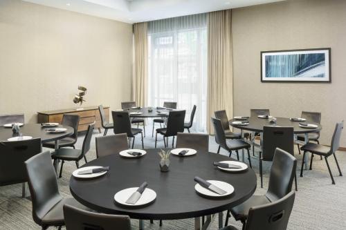 a conference room with tables and chairs and a window at AC Hotel by Marriott Chapel Hill Downtown in Chapel Hill