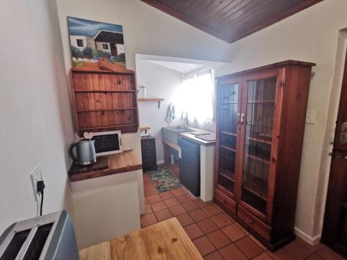 a small kitchen with a sink and a stove at Authentic Farmstyle Stay in Aloe Valley in Albertinia