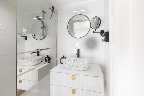 La salle de bains blanche est pourvue de deux lavabos et de miroirs. dans l'établissement 2 Pièces terrasse Jacuzzi privatif dans villa à 5 minutes de Sophia Antipolis, à Valbonne