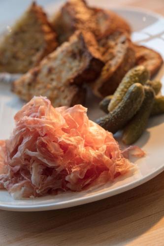 a plate of food with meat and pickles on a table at AC Hotel by Marriott San Jose Downtown in San Jose