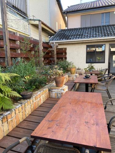 two wooden tables and chairs on a patio at AGASA residence in Fujieda