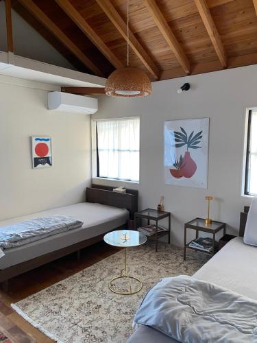 a living room with two beds and a table at AGASA residence in Fujieda