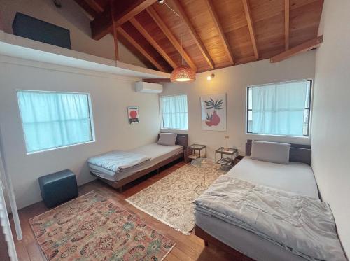 a bedroom with two beds and a rug at AGASA residence in Fujieda