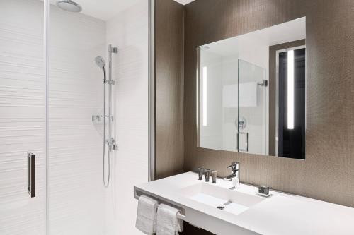 a bathroom with a sink and a shower with a mirror at AC Hotel by Marriott Phoenix Tempe/Downtown in Tempe