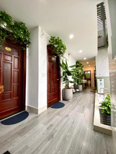 a hallway with a wooden door and potted plants at Dom Hostel Old Town Hoi An in Hoi An