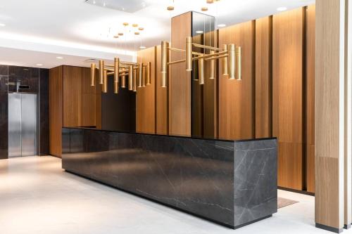 a lobby with a reception desk and chandeliers at AC Hotel by Marriott Riga in Rīga