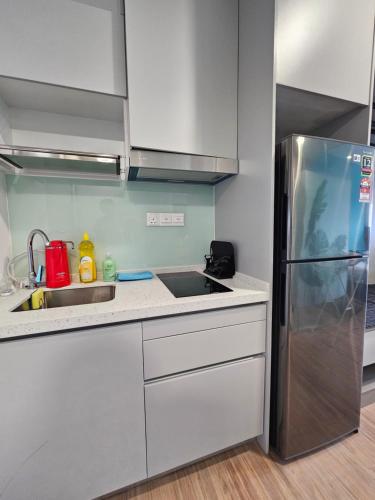 a kitchen with a sink and a refrigerator at Riveria City by Nomadnest in Kuala Lumpur