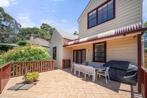 a patio with a table and chairs next to a house at Charming House in Woolwich in Sydney