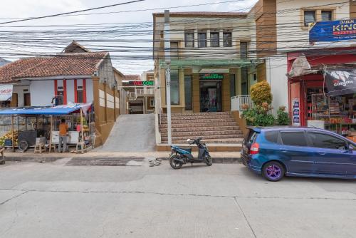 a blue minivan parked in front of a building at Urbanview Syariah Utami Inn Garut by RedDoorz in Garut