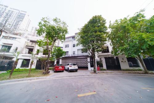 a street with cars parked in front of a white building at Lam Anh Hotel 4 Ngoại Giao Đoàn BT6-19 in Hanoi