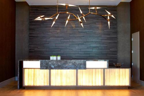 - un bar dans le hall avec un mur en briques dans l'établissement AC Hotel by Marriott Atlanta Buckhead at Phipps Plaza, à Atlanta