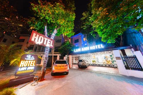a hotel sign and a car parked in a parking lot at Lam Anh Hotel 4 Ngoại Giao Đoàn BT6-19 in Hanoi