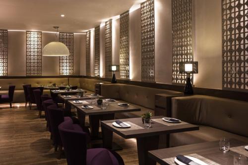 a dining room with tables and chairs and windows at AC Hotel by Marriott Panama City in Panama City