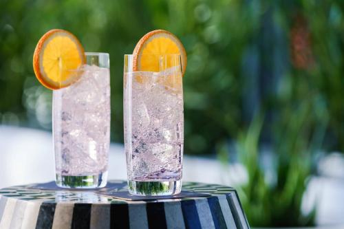 two glasses of water and an orange slice on a table at AC Hotel by Marriott Scottsdale North in Scottsdale