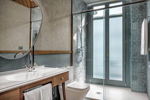 a bathroom with a sink and a toilet and a mirror at Palacio Santa Clara, Autograph Collection in Valencia