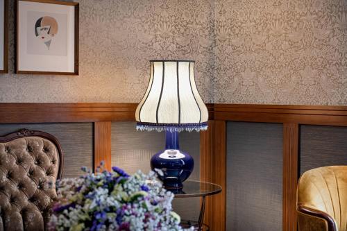 a blue lamp sitting on a table next to a bunch of flowers at Palacio Santa Clara, Autograph Collection in Valencia