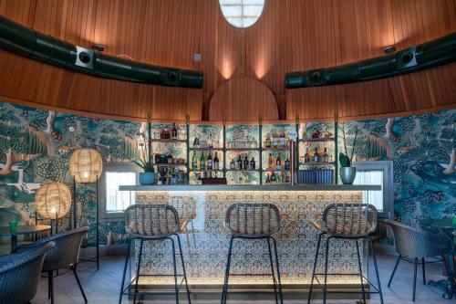a restaurant with a bar with chairs in front of it at Palacio Santa Clara, Autograph Collection in Valencia