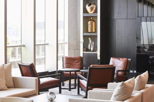 a living room with chairs and tables and windows at AC Hotel by Marriott Santiago Cenco Costanera in Santiago