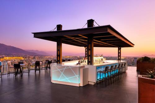 a bar on the roof of a building with a view at AC Hotel by Marriott Santiago Cenco Costanera in Santiago