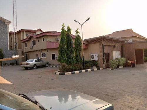 a car parked in a parking lot in front of buildings at Choice Gate Hotel-Business Double in Benin City