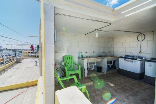 a kitchen with green chairs and a table on a roof at 1 Bedroom-Apartment 3 Single Beds in Corales del Sur, Santo Domingo Este in La Viva