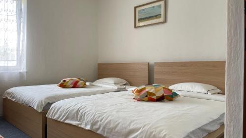 two beds in a room with white walls at Cosy Country House U Faflika with Sauna and 2 bathrooms in Vlkov