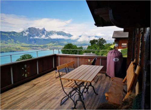 a table and chairs on a balcony with a view of a mountain at Chalet with panoramic views of the mountains of the Oberland and Lake Thun in Sigriswil