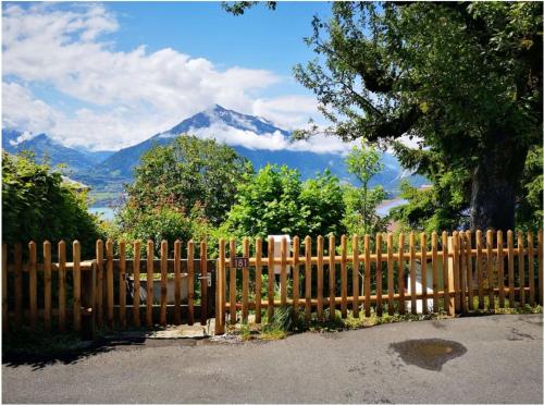 a wooden fence with a mountain in the background at Chalet with panoramic views of the mountains of the Oberland and Lake Thun in Sigriswil