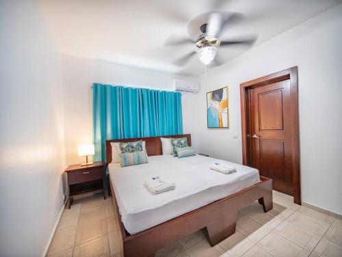 Un dormitorio con una cama y un ventilador de techo. en 7br Massive Villa In Sosa - 2mins From Nightlife, en Sosúa