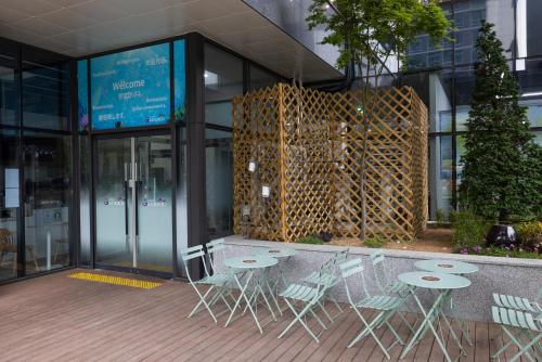 a group of tables and chairs in front of a building at Grand Bleu Hotel & Residence in Incheon