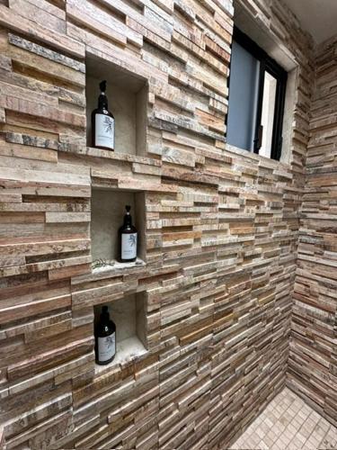 a brick wall with three bottles on it at Casa Madera 2A in Zacatlán