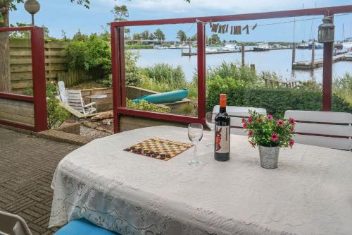a table with a bottle of wine and two glasses at Tolles 2 Pers Haus König mit Hafenblick am Lauwersmeer in Anjum
