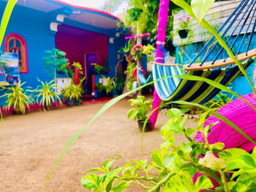 a house with a blue and pink building with plants at Hema Holiday Villa in Trincomalee