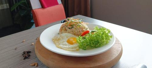 a plate of food with eggs and vegetables on a table at Manhattan Hotel Ipoh in Ipoh