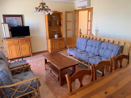 a living room with a blue couch and a table at Beachfront Bungalow In La Mata, Torrevieja in Torrevieja