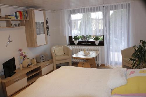 a bedroom with a bed and a table and a window at Rügenurlaub 1 in Bergen auf Rügen