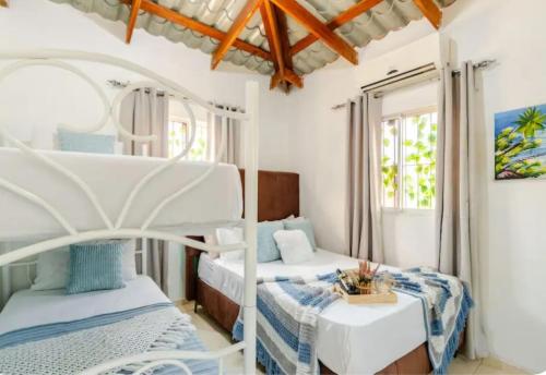 a bedroom with two bunk beds and a table at Escape to Puerto Plata, Cozy 2BR Loft in Las Mercedes, 5 Min from Beaches in Isabel de Torres