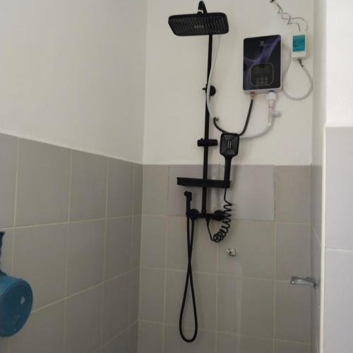 a shower with a phone in a bathroom at M-J Room Rental in Alcoy