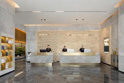 a lobby with two people sitting at reception desks at Atour Hotel Zhongshan Henglan Chang New Times Square in Zhongshan