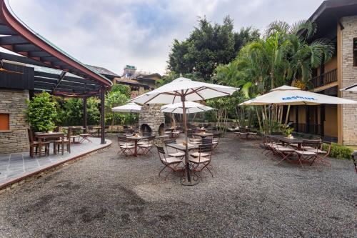a patio with tables and chairs and umbrellas at Temple Tree Resort & Spa, Pokhara in Pokhara